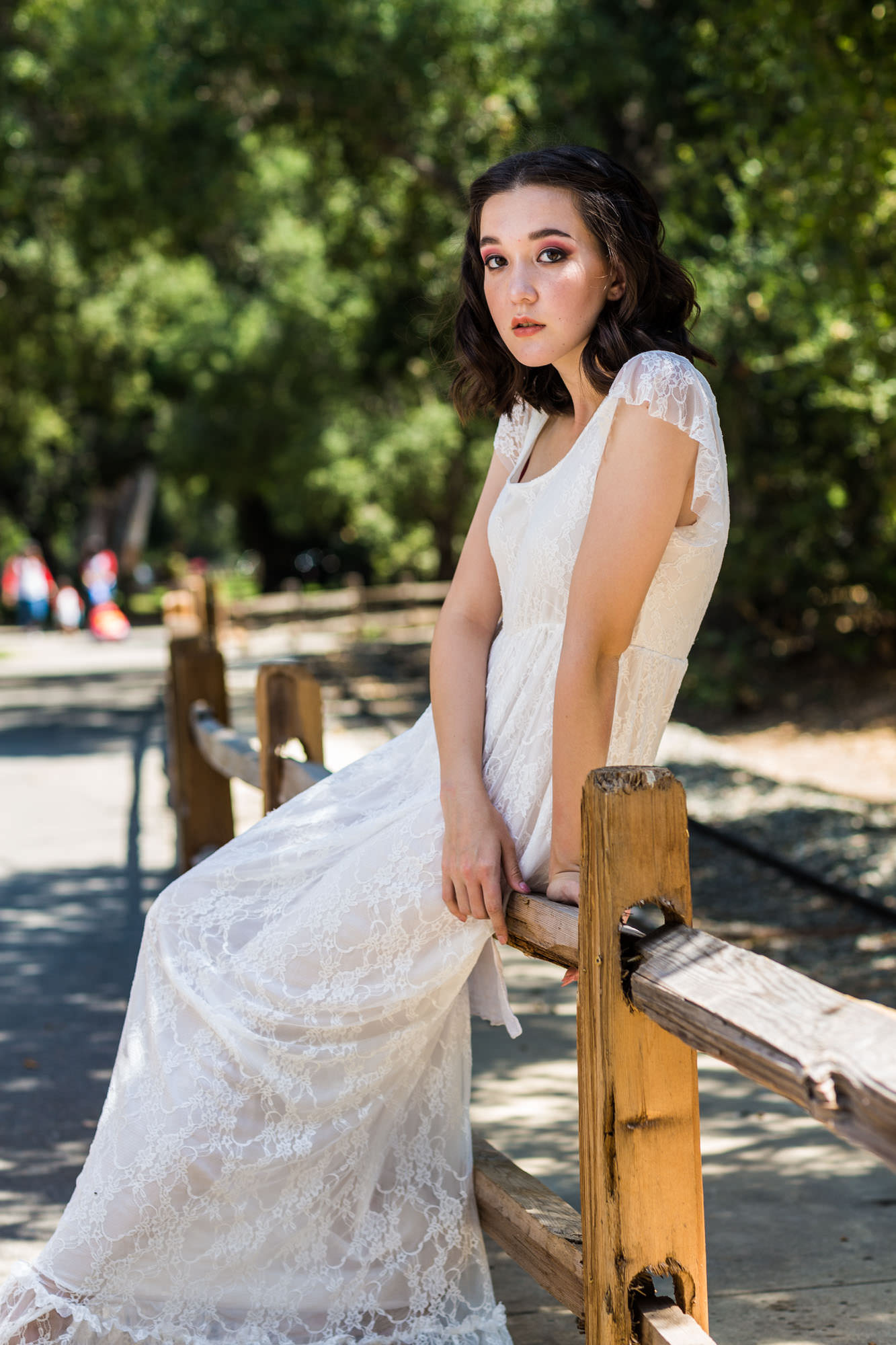 Asian Lady sitting on a split rail fence